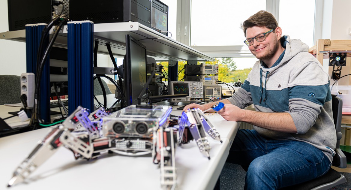 Studierender programmiert einen Roboter