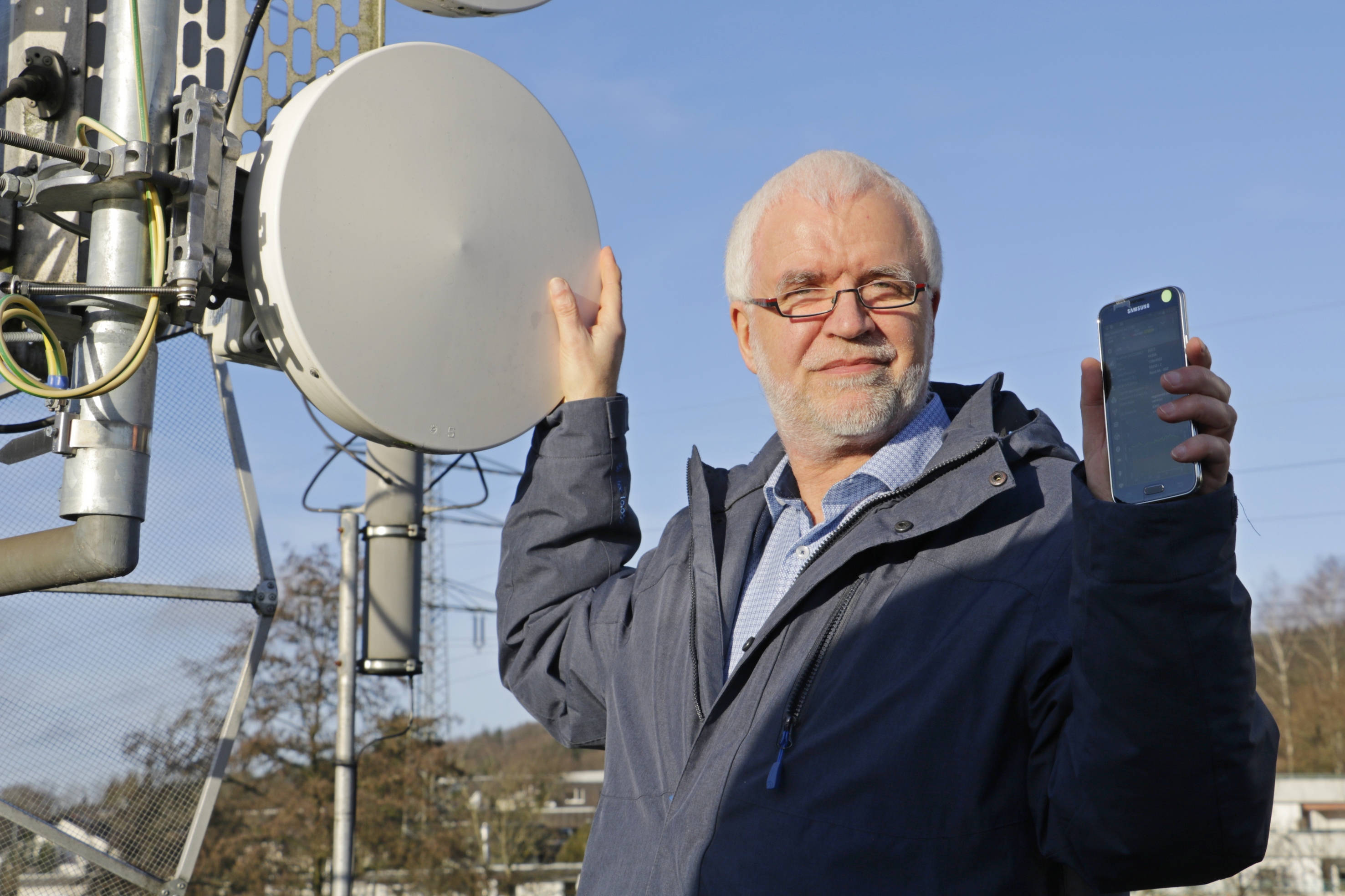 Prof. Dr. Christian Lüders mit einer von zahlreichen Richtfunkantennen, die für die Funkübertragung im 5G-Mobilfunkstandard erforderlich sind Foto: Christian Klett, FH Südwestfalen