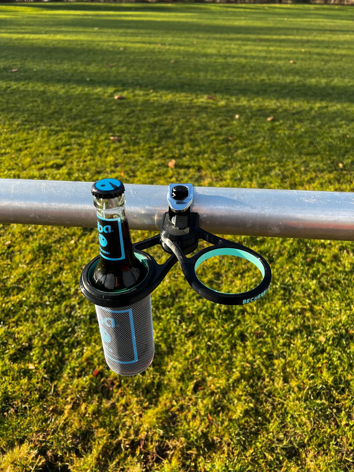 Der „Becherbuddy“ wird mühelos und unkompliziert an der Sportplatzbarriere angebracht. Foto: FH / Mona Richter