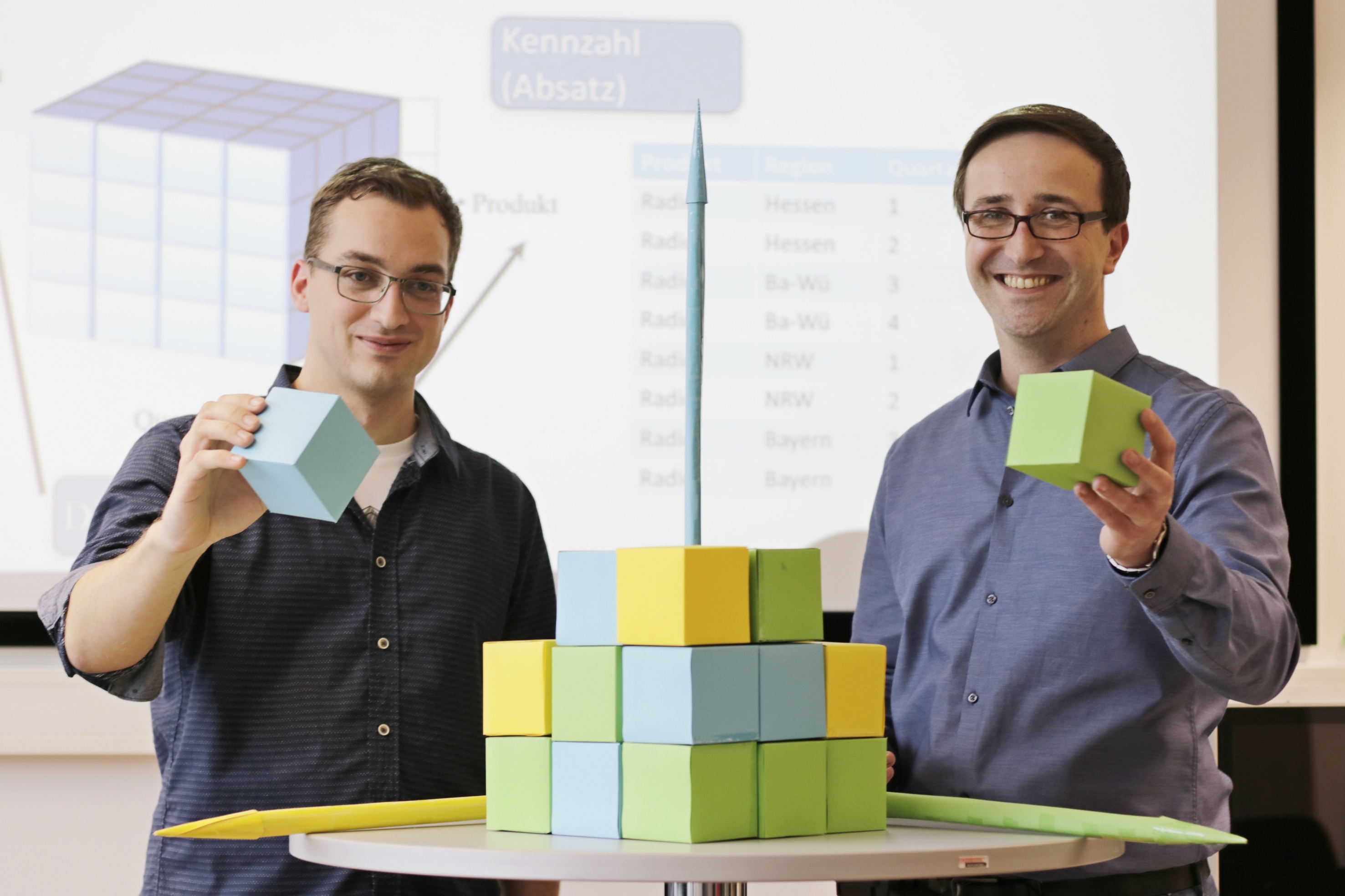 Robin Ahlers und André Ruegenberg erklären das Prinzip der Datenmodellierung mit einem „Datenwürfel“: Welche Daten benötige ich, welche Muster sind zu erkennen? Foto: Christian Klett, FH Südwestfalen