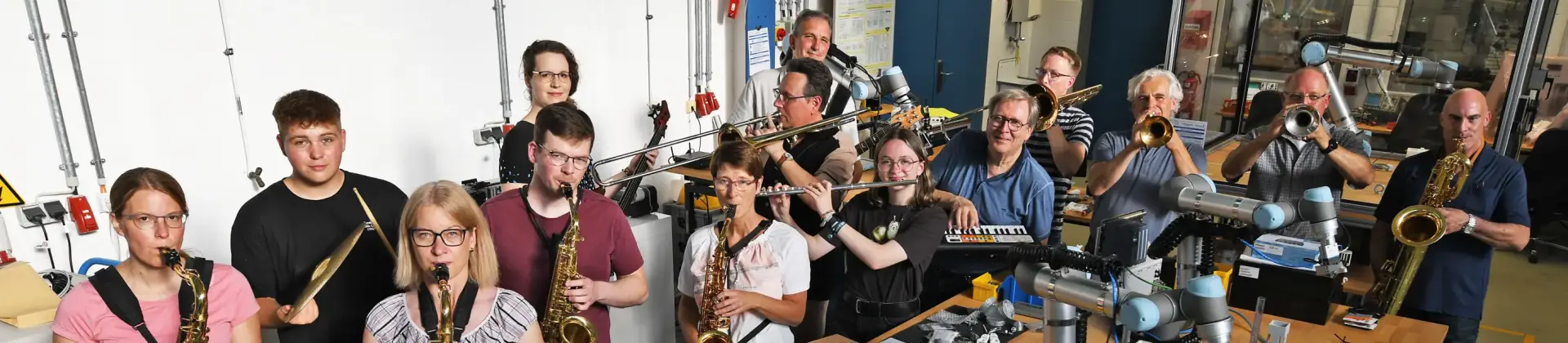 Die Musikerinnen und Musiker der FH Big Band im Roboterlabor des Fachbereichs Maschinenbau-Automatisierungstechnik. Foto: Ludger Knoke 
