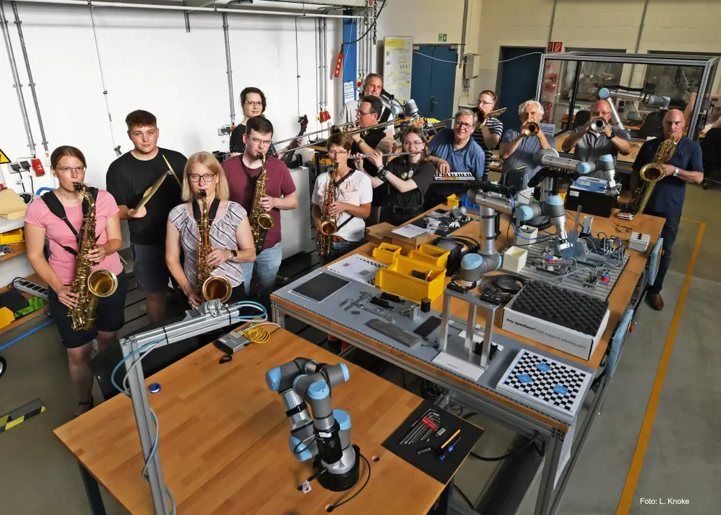 Die Musikerinnen und Musiker der FH Big Band im Roboterlabor des Fachbereichs Maschinenbau-Automatisierungstechnik. Foto: Ludger Knoke 