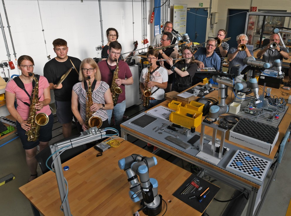 Die Musikerinnen und Musiker der FH Big Band im Roboterlabor des Fachbereichs Maschinenbau-Automatisierungstechnik. Foto: Ludger Knoke 