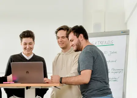 Studierende Personen in einem Raum mit einem Flipchart mit dem Thema Megatrends