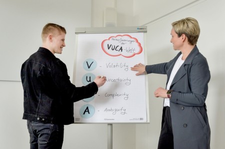 Professorin erklärt Studierendem an Flipchart die 