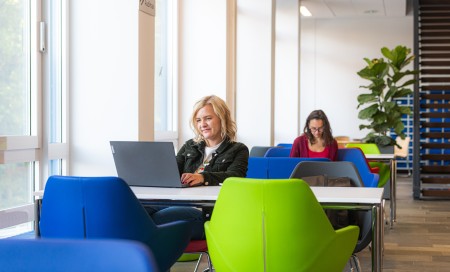 Studierende lernen am Laptop im Foyer