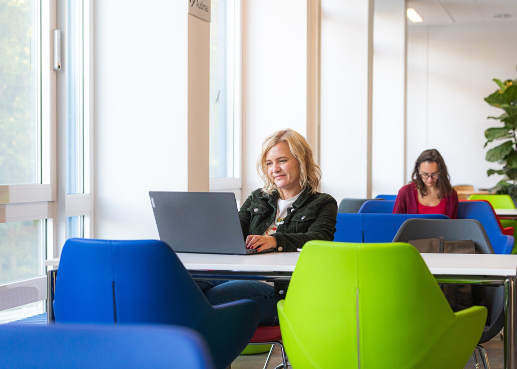 Studierende lernen am Laptop im Foyer