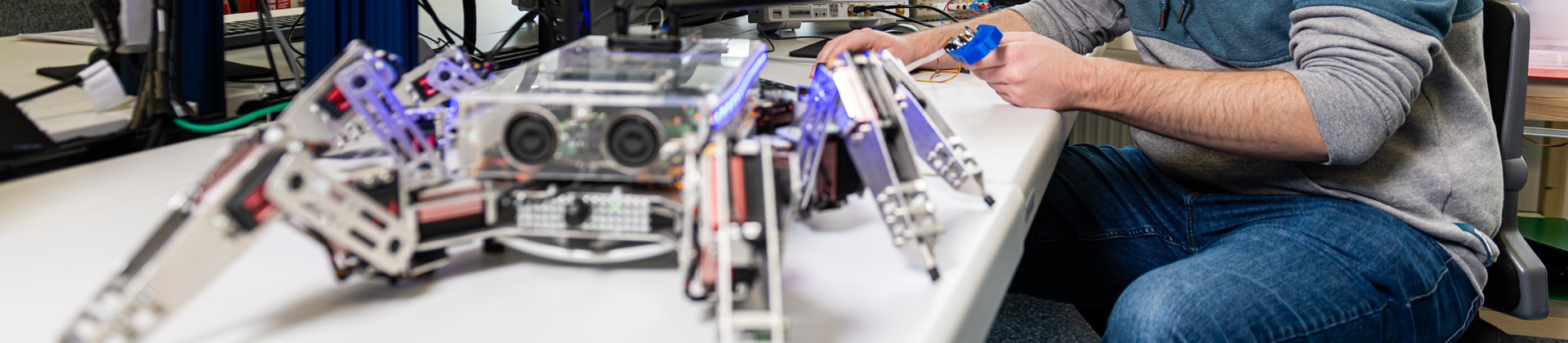 Studierender programmiert einen Roboter