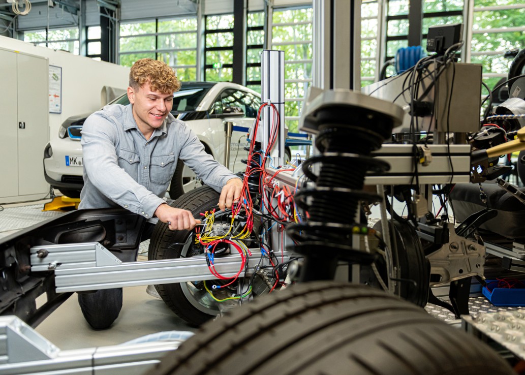 Studierender am Auto in der Automotive Halle