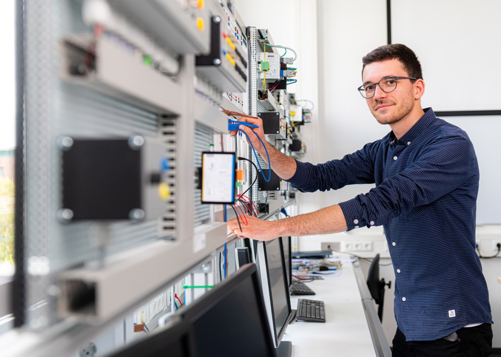 Studierender steht an einer Maschine