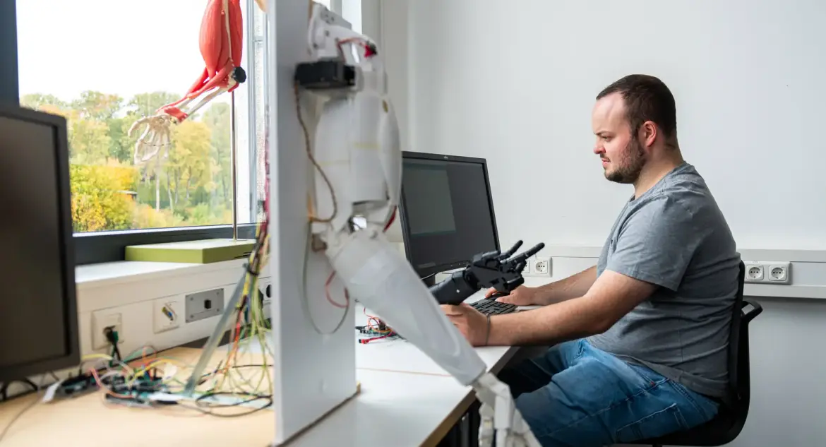 Studierender arbeitet mit Roboterarm