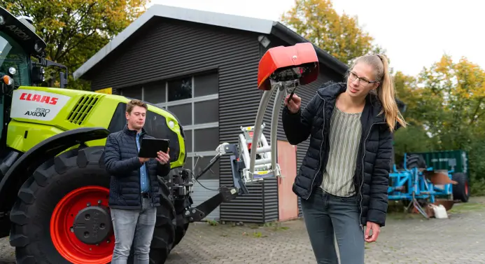 Zwei Studierende vor Traktor