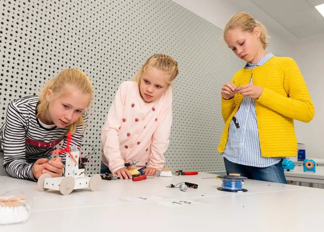 Drei Kinder bauen an einem Modell