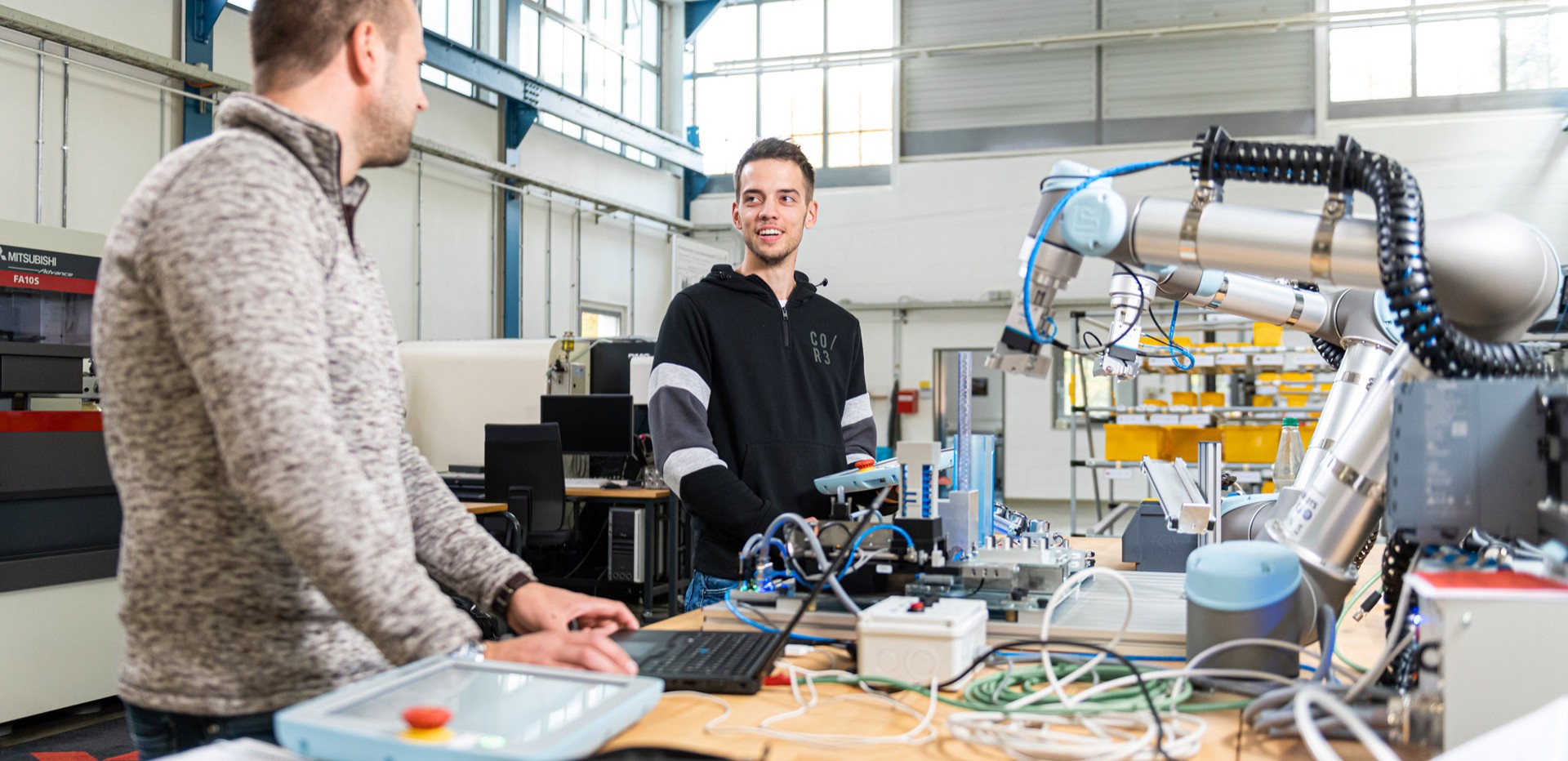Zwei Studierende arbeiten an einem Universal Roboter