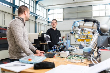 Zwei Studierende arbeiten an einem Universal Roboter