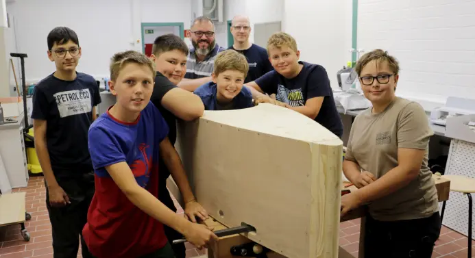 Die sechs Teilnehmer mit ihrer Seifenkiste im Rohbau und den Betreuern Victor Holstein und Bastian Obertegger 
