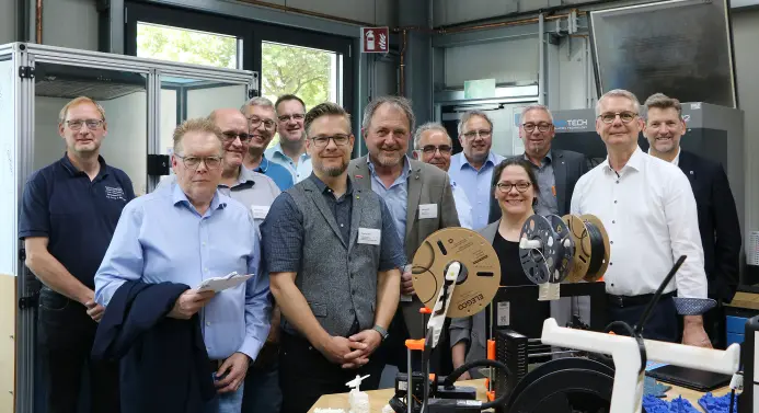 Eine Gruppe von Menschen in einer Werkstatt.