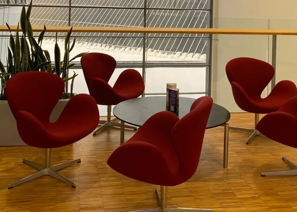 Vier Stühle und ein runder Tisch in einem Gebäude.